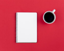 Blank notepad and coffee cup on the red background