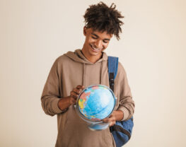 Positive young man with globe in his hands