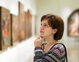 A woman is looking at pictures in an art gallery