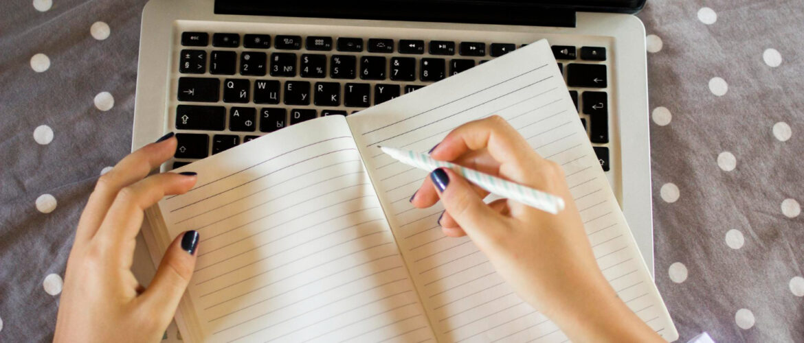 Woman's hands start to write on an empty notepad