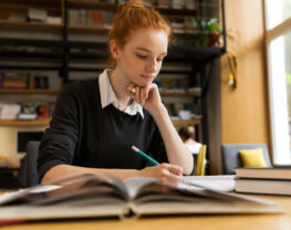 A young woman is writing in the library